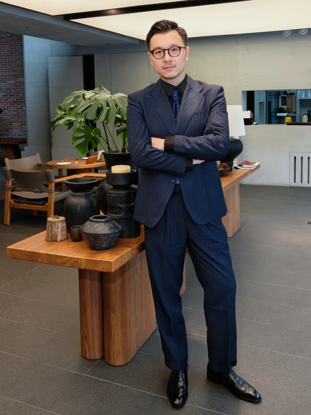 彭勃穿深色西装，站在室内